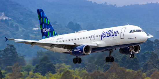 jetblue airplane landing with mountains in background