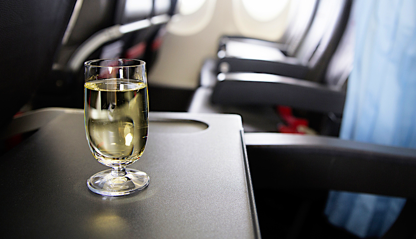 Wine on a tray table on an airplane