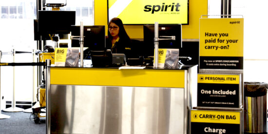Spirit Airlines gate check-in counter with agent and bag sizer