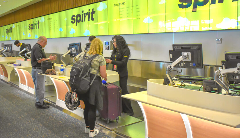 woman checks in at Spirit Airlines ticket counter