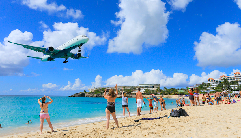 People watching planes touchdown in St. Maarten Maho Beach