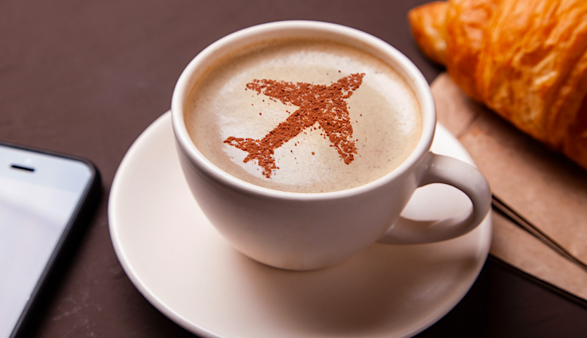Mug of coffee with airplane image in foam